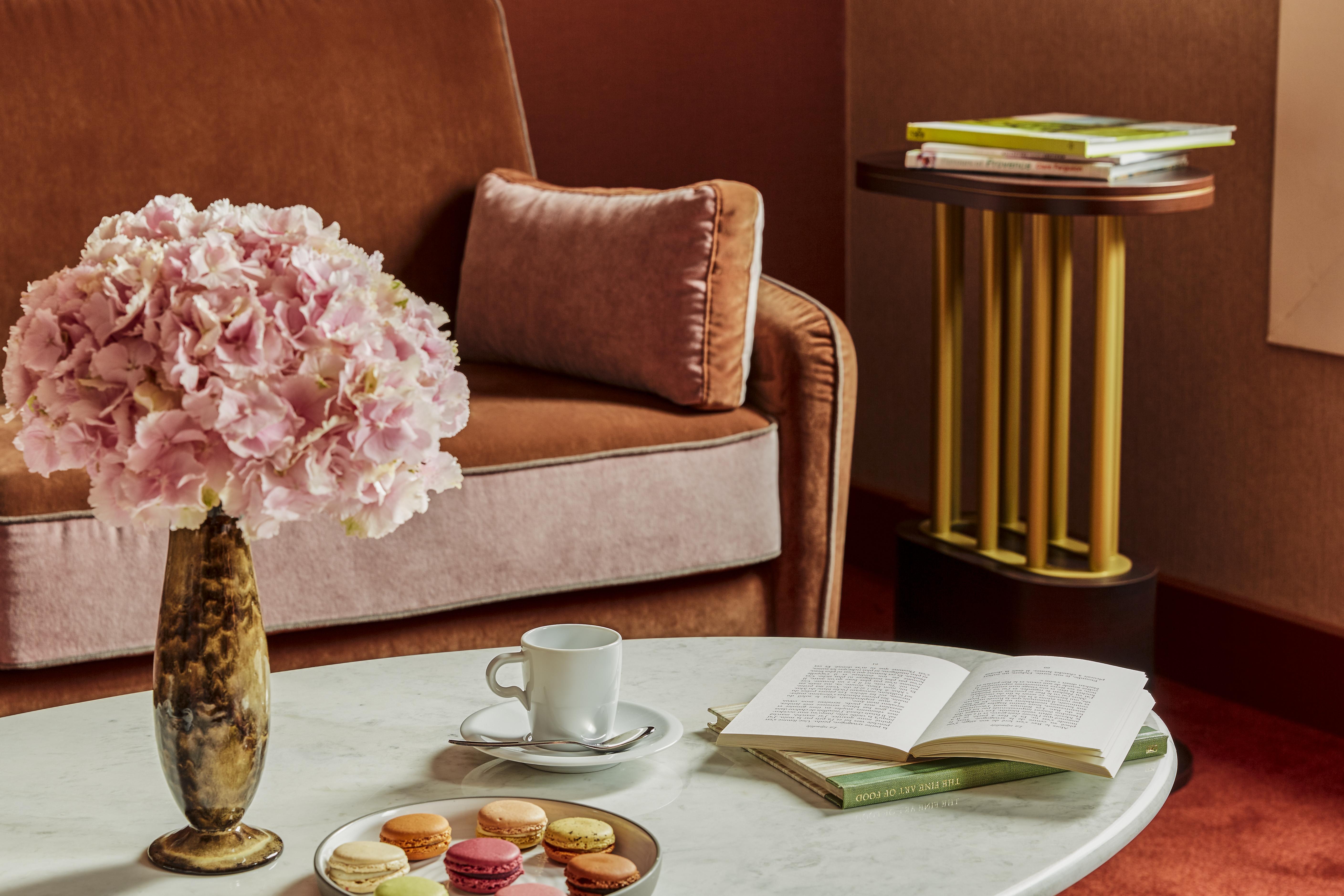 Nest Paris La Defense - Mgallery Puteaux Bagian luar foto A table with a coffee cup and saucer, a book, and a vase of flowers