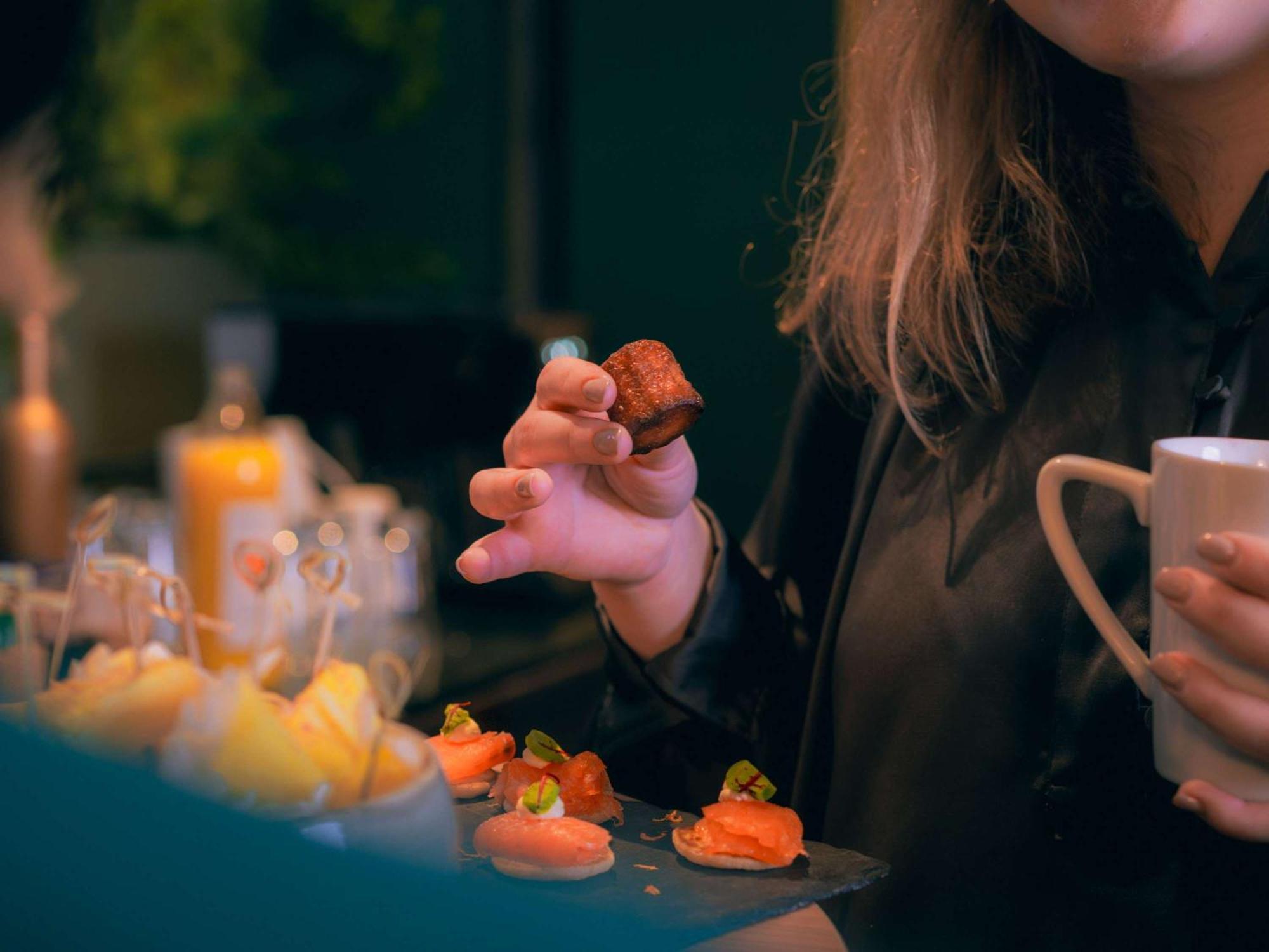 Nest Paris La Defense - Mgallery Puteaux Bagian luar foto A woman holding a piece of sushi